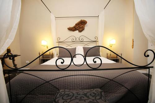 ローマにあるAmica Roma Guest Houseのベッドルーム1室(黒い錬鉄製のヘッドボード付)