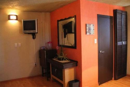 ein Wohnzimmer mit orangefarbenen Wänden und einem Spiegel in der Unterkunft Hotel Miramar - La Paz in La Paz