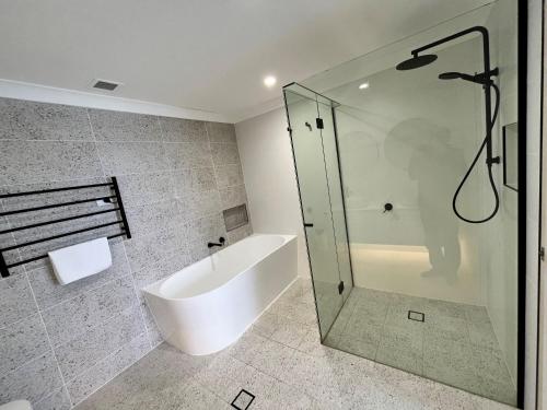 a bathroom with a shower and a bath tub at Avoca Palms Resort in Avoca Beach