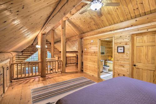 a log cabin bedroom with a bed and a staircase at Splendid Family Cabin with Hot Tub and Grill! in Lake City