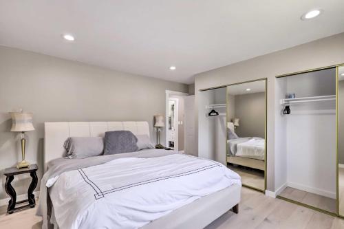 a bedroom with a white bed and a mirror at Deck and Yard Pet-Friendly Apartment in Magna! in West Valley City
