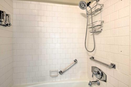 a white tiled bathroom with a shower and a tub at Salt Lake City Condo Less Than 28 Mi to Ski Resort! in Salt Lake City