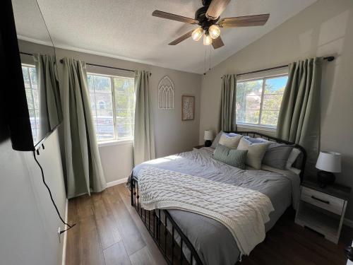 a bedroom with a bed with a ceiling fan and windows at Mid City Condo in Huntsville