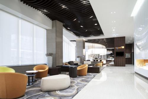 a lobby of a hotel with chairs and tables at Novotel Ambassador Suwon in Suwon