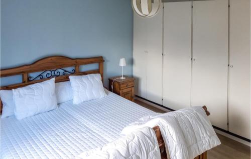 1 dormitorio con 1 cama con sábanas blancas y cabecero de madera en Cozy Apartment In Paulistrm With Kitchen en Pauliström