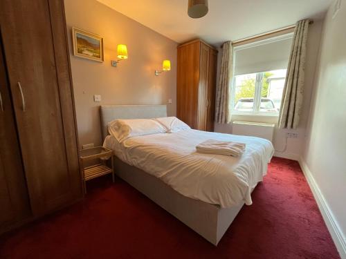 a small bedroom with a bed and a window at Sandymount House & Garden in Dublin