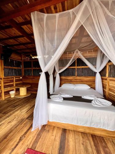 a bedroom with a bed with a mosquito net at Coco Lodge, vista al mar in La Poza