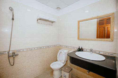 W łazience znajduje się toaleta, umywalka i lustro. w obiekcie Lien Huong Hotel w mieście Da Lat