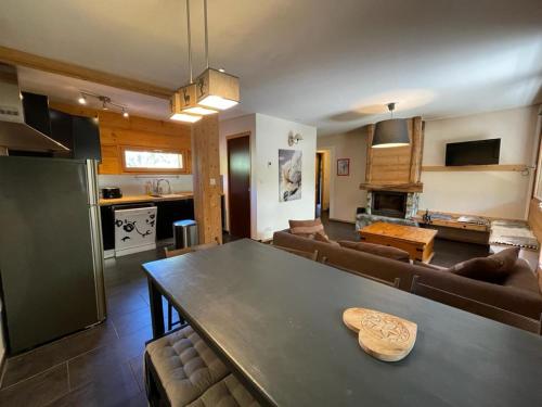 Il comprend une cuisine et un salon avec une table. dans l'établissement Appartement 4 chambres avec grande terrasse, à Les Deux Alpes