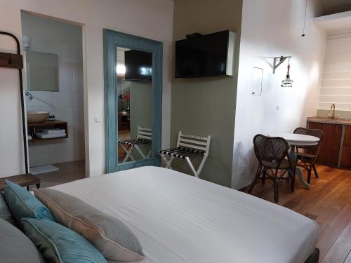 a bedroom with a bed and a table and chairs at Couleur Locale Paramaribo in Paramaribo