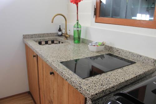 a kitchen counter with a sink and a bottle of wine at Couleur Locale Paramaribo in Paramaribo