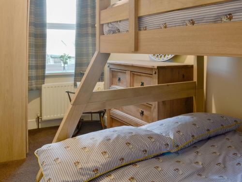 a bedroom with a bunk bed and a dresser at Marleys Retreat in Seaton Delaval