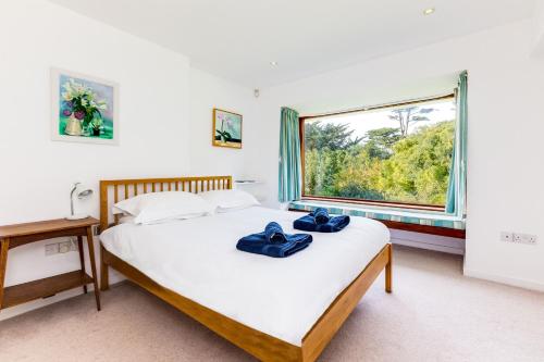 a bedroom with a bed and a large window at Little Trig in Padstow