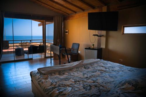 1 dormitorio con cama y vistas al océano en Mahalo Lobitos, en Lobitos