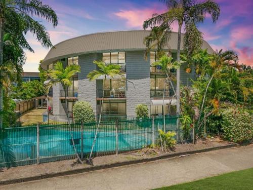 a house with a swimming pool in front of a fence at Modern Apartment Close to the City Centre 16 in Cairns