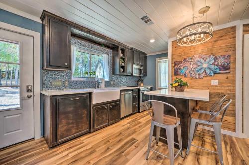 a kitchen with wooden cabinets and a table and chairs at Modern Broken Bow Cabin, Near Lake and Wineries in Broken Bow