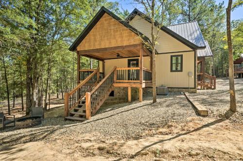 a cabin in the woods with a porch and a deck at Modern Broken Bow Cabin, Near Lake and Wineries in Broken Bow
