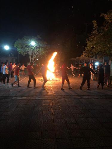 a group of people dancing around a fire at night at Khách sạn Vườn Quốc gia Ba Bể in Bak Kan