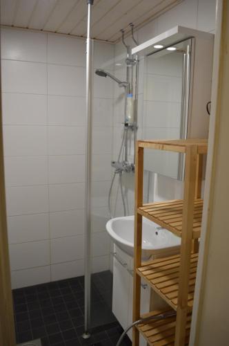 uma casa de banho com um chuveiro e um lavatório branco em Polar Haven em Rovaniemi