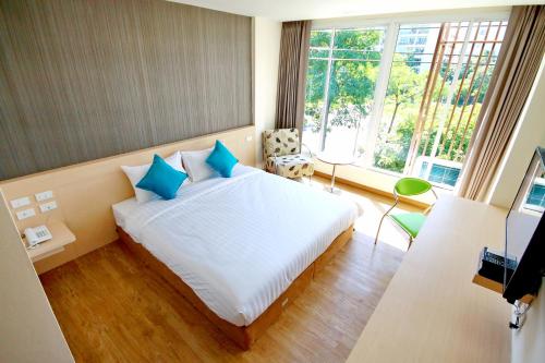 a bedroom with a large white bed with blue pillows at S3 Residence Park in Bangkok