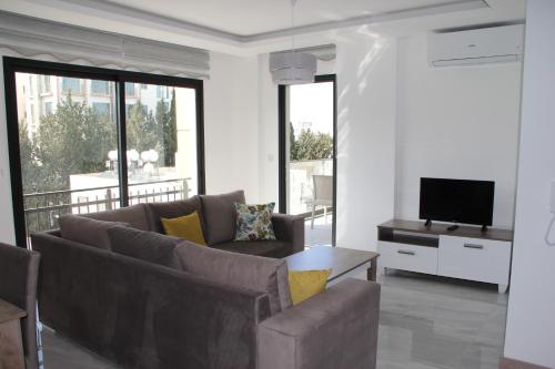uma sala de estar com um sofá e uma televisão em Okman Homes em Cirénia