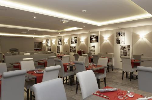 a restaurant with tables and chairs and pictures on the walls at La Table de Gustave in Ornans