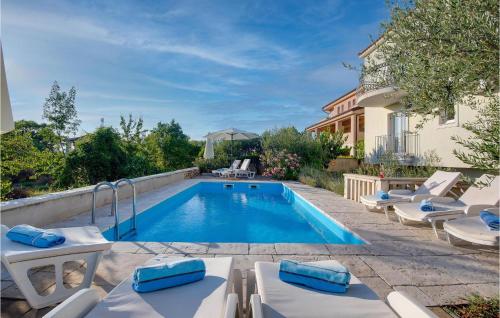 a swimming pool with lounge chairs next to a house at Amazing Home In Linardici With Wifi in Linardići