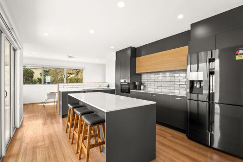 a kitchen with a large island and a black refrigerator at La Calma in San Remo
