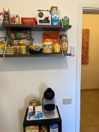 a shelf with food on it next to a refrigerator at B&B Cristina Garden in Pisa