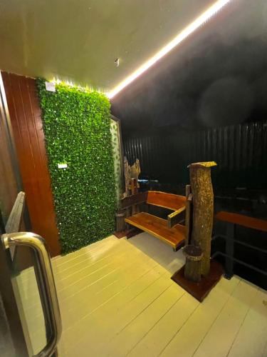 a room with a green wall and a bench at Noree Deluxe in Ban Phan Sadet Nai