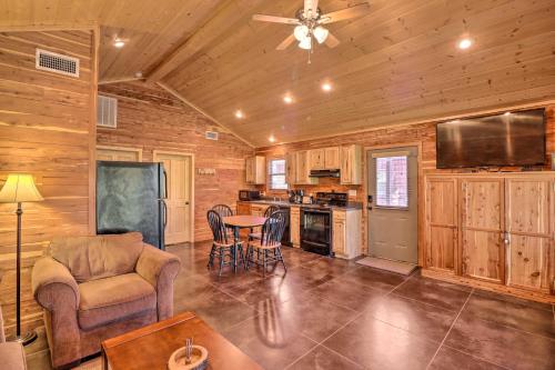 a living room with a table and chairs and a ceiling fan at Heber Springs Cabin with Deck and River Views! in Heber Springs