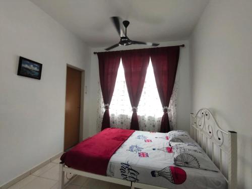 a bedroom with a bed with a red curtain and a window at HOMESTAY HAIKALHAIDAR in Rantau Panjang