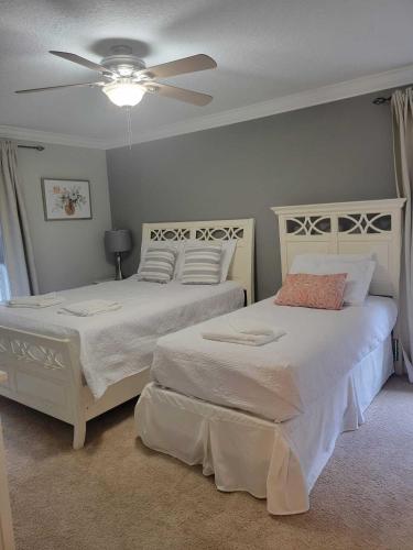 a bedroom with two beds and a ceiling fan at Paradise Villa Disney Staycation Pool, Fun & Resort Access in Kissimmee