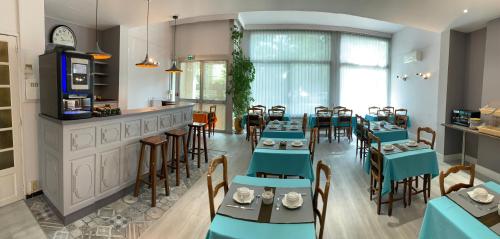 un restaurant avec des tables et des chaises bleues et un bar dans l'établissement Logis Hotel du Midi, à Salon-de-Provence