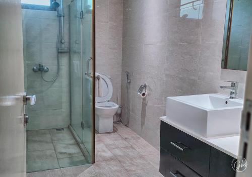 a bathroom with a shower and a sink and a toilet at Grand Bay Suites in Grand Baie