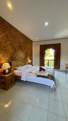 a bedroom with a large bed in a room at Satria Bungalow in Uluwatu