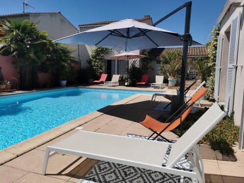 einen Stuhl und einen Regenschirm neben einem Pool in der Unterkunft Gîtes, Chambres d'Hôtes La Maison d'Amis in Puilboreau