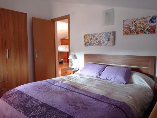 een slaapkamer met een groot bed met paarse lakens bij La Vie en Rose in Cartagena