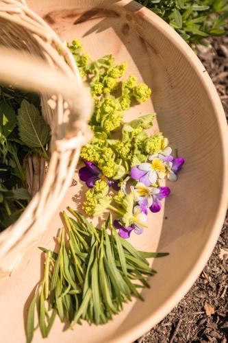 a basket filled with flowers and a bunch of broccoli at Naturhotel Landhof Irschen in Irschen