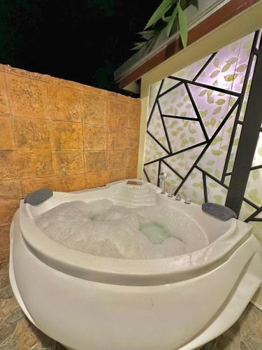 a bath tub with a toilet in a bathroom at Noree Supreme in Ban Phan Sadet Nai
