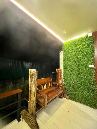 a bench in a room with a green wall at Noree Supreme in Ban Phan Sadet Nai