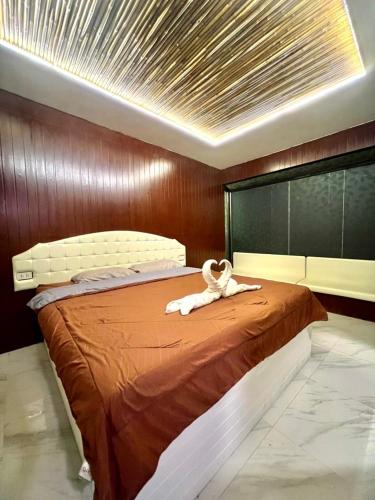 a bed with a white animal laying on top of it at Noree Supreme in Ban Phan Sadet Nai
