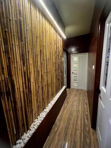 a hallway with a wall of bambooambooambooambooambooambooambooambooambooamboo at Noree Supreme in Ban Phan Sadet Nai