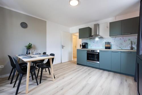 a kitchen with blue cabinets and a table and chairs at Apartement in Zell in Zell am Main