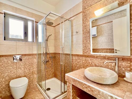 uma casa de banho com um lavatório, um chuveiro e um WC. em Luxury Villa San George with private pool by DadoVillas em Nydri