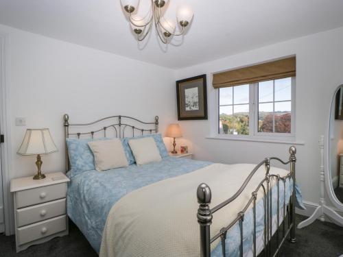 a bedroom with a bed and a window at Pound Cottage in Lyme Regis