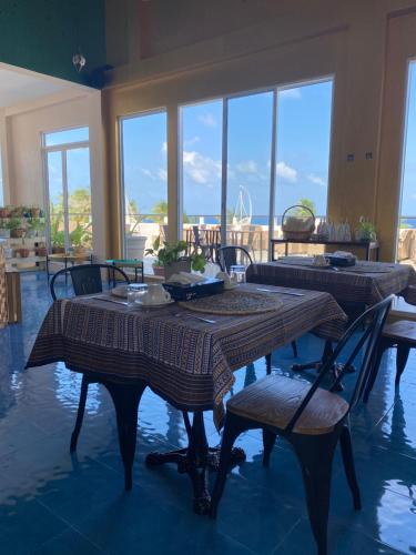 a dining room with tables and chairs and windows at Lea Spa Hotel in Maafushi