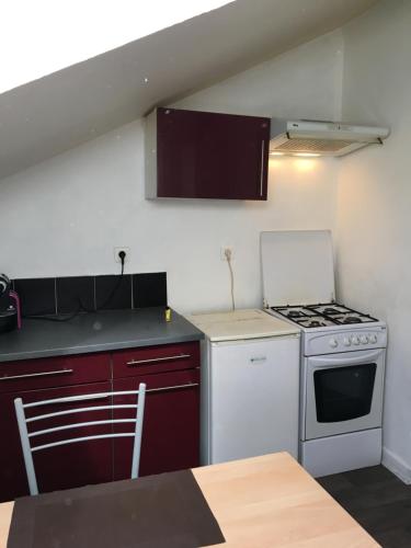 Il comprend une cuisine équipée d'une cuisinière et d'un four blanc. dans l'établissement Le Victor Hugo 4 D et sa pizza offerte, à Aurillac