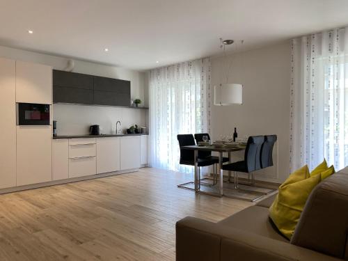 uma sala de estar com uma cozinha e uma mesa com cadeiras em Neu, zentral, sonnig, Garage inklusive em Merano