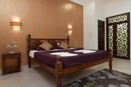 a bedroom with a large bed with purple sheets at Villa Calangute Phase 5 in Calangute